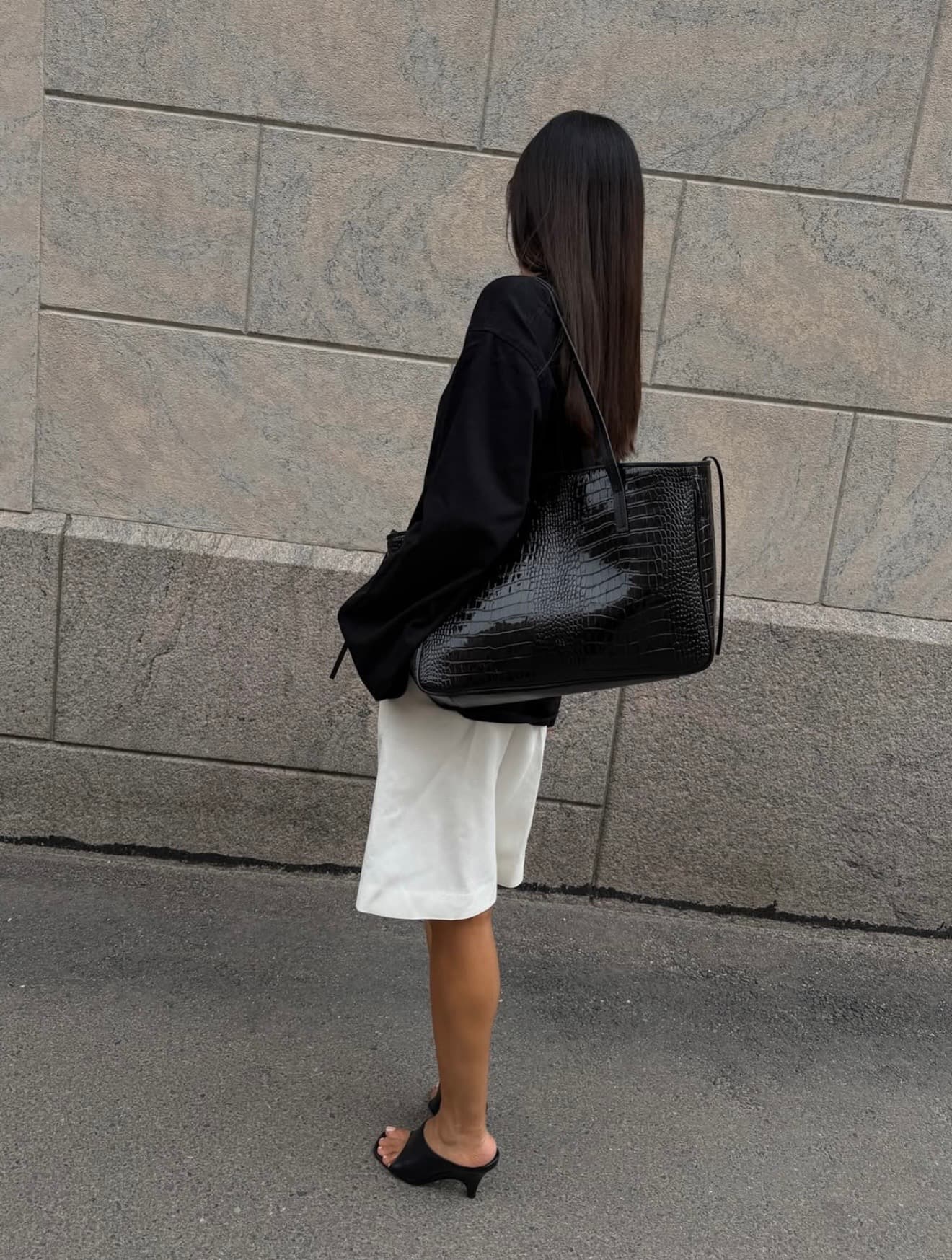 Black tailoring styled with an ivory skirt and oversized textured bag